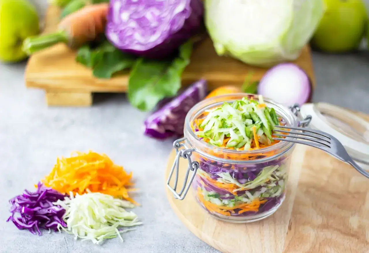 Kolorowa surówka coleslaw w słoiku, z widoczną różnicą między surówką coleslaw a klasyczną mizerią z octem.
