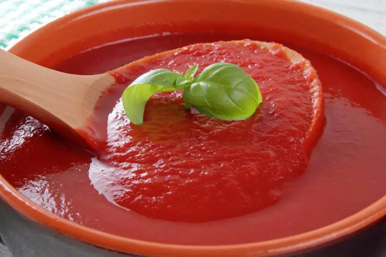 Domowy ketchup do frytek o niskiej zawartości cukru, z bazylią, w ceramicznej misce.