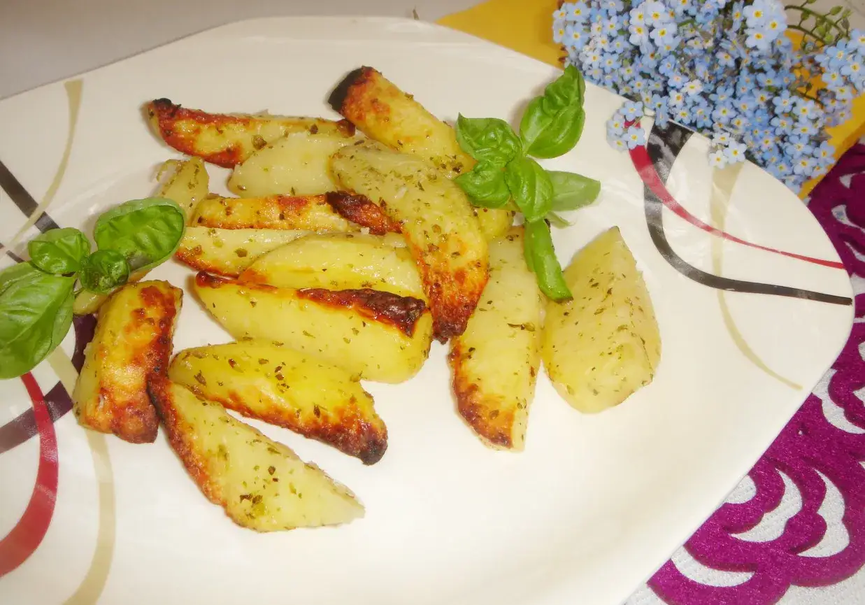 Pieczone ziemniaki z ziołami, czosnkiem i odrobiną parmezanu. Jakie przyprawy dodać do frytek poza solą, papryką wędzoną i parmezanem? Zioła prowansalskie!