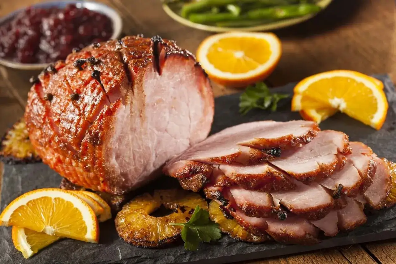 Pieczona szynka z pomarańczą i ananasem. Idealna temperatura pieczenia szynki to klucz do jej soczystości.