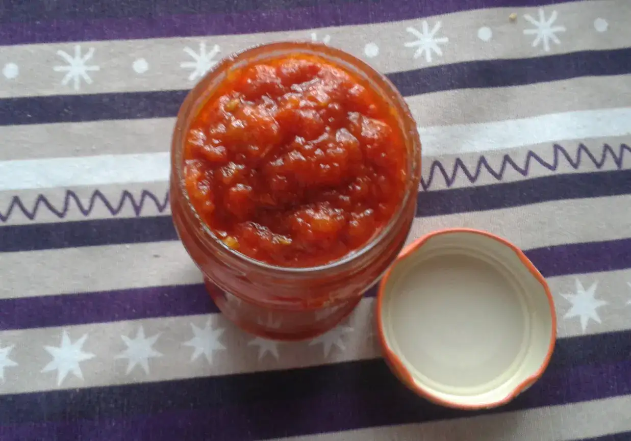 Domowy ketchup do frytek o niskiej zawartości cukru w słoiku, obok otwarta pokrywka.