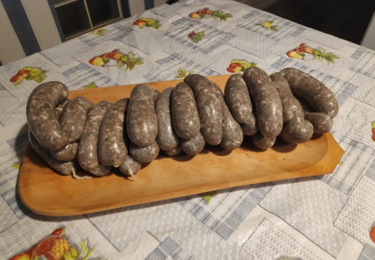 Domowa biała kiełbasa bez maszynki, ułożona na drewnianej desce.