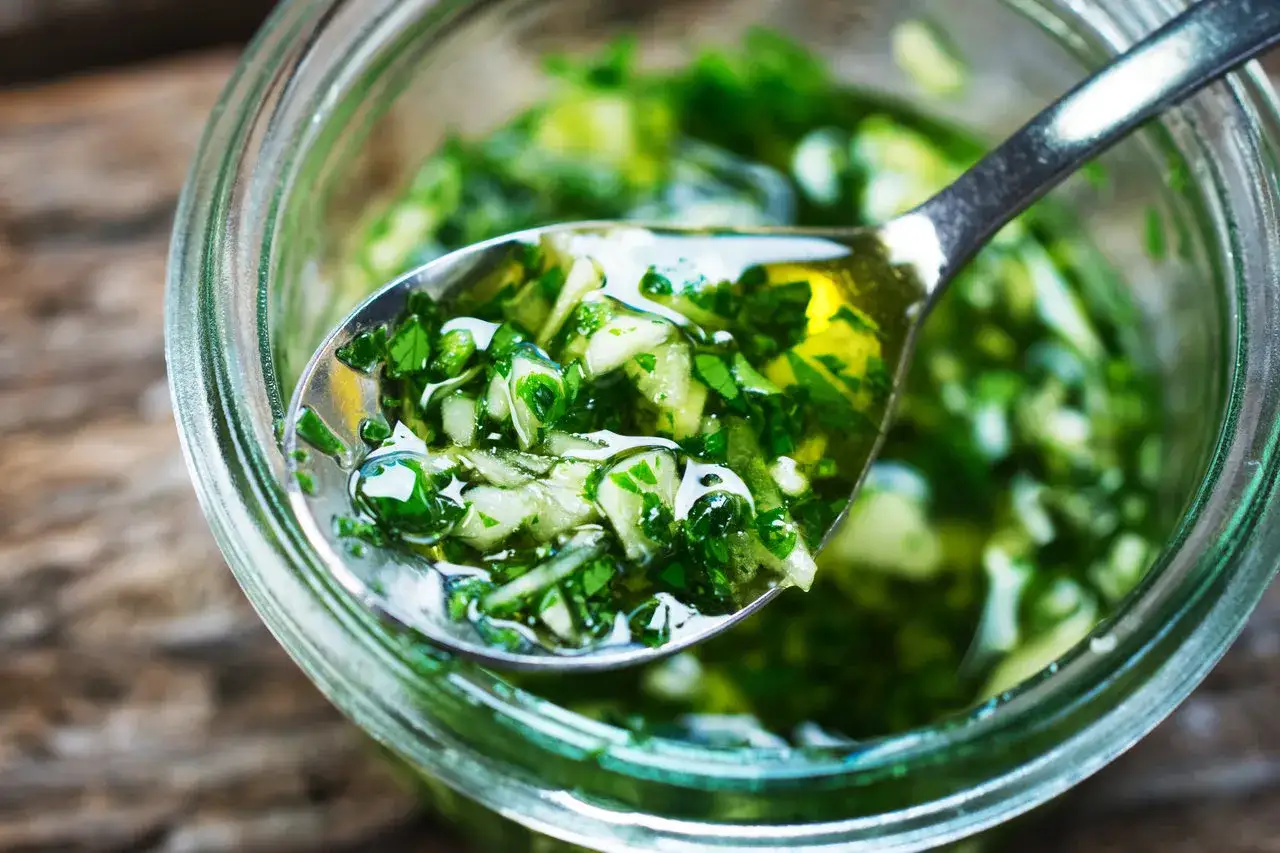 Świeży sos chimichurri w słoiku, idealny do mięsa z grilla. Poznaj przepis, jak przygotować ten aromatyczny dodatek.