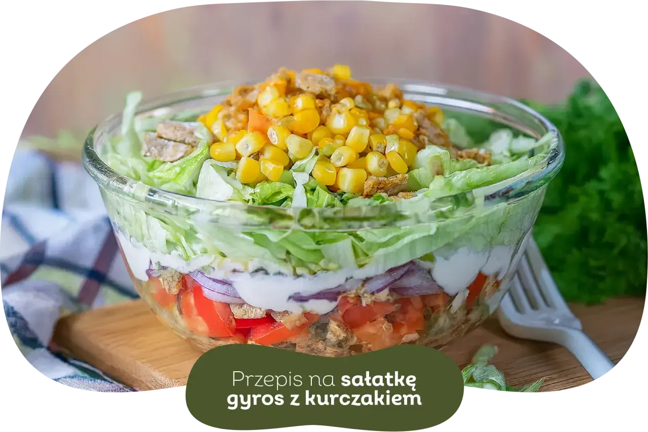 Warstwowa sałatka gyros z kurczakiem, pomidorami, cebulą i kukurydzą. Idealna, gdy zastanawiasz się, czy sałatkę gyros można zrobić dzień wcześniej.
