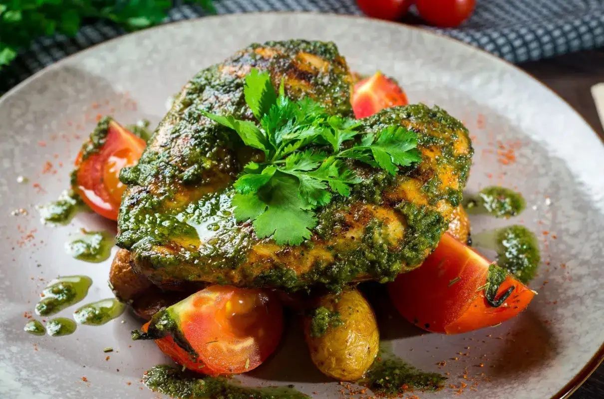Grillowane mięso z kurczaka polane sosem chimichurri, podane z pomidorkami i ziemniakami. Idealny przepis na sos chimichurri do mięsa z grilla.