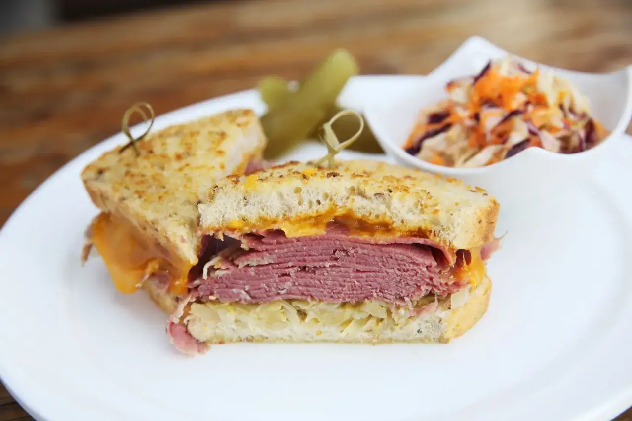 Domowe pastrami z mostka wołowego: kanapka z serem, kiszoną kapustą i surówką. Idealne na obiad, gdy wiesz, jak przygotować domowe pastrami z mostka wołowego krok po kroku.