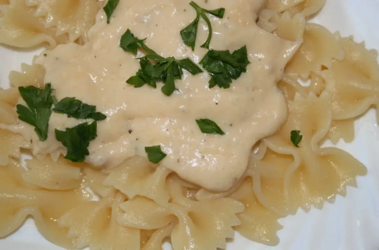 Pyszny, kremowy sos do makaronu farfalle, posypany świeżą natką pietruszki. Idealny przepis, jak zrobić sos do makaronu.