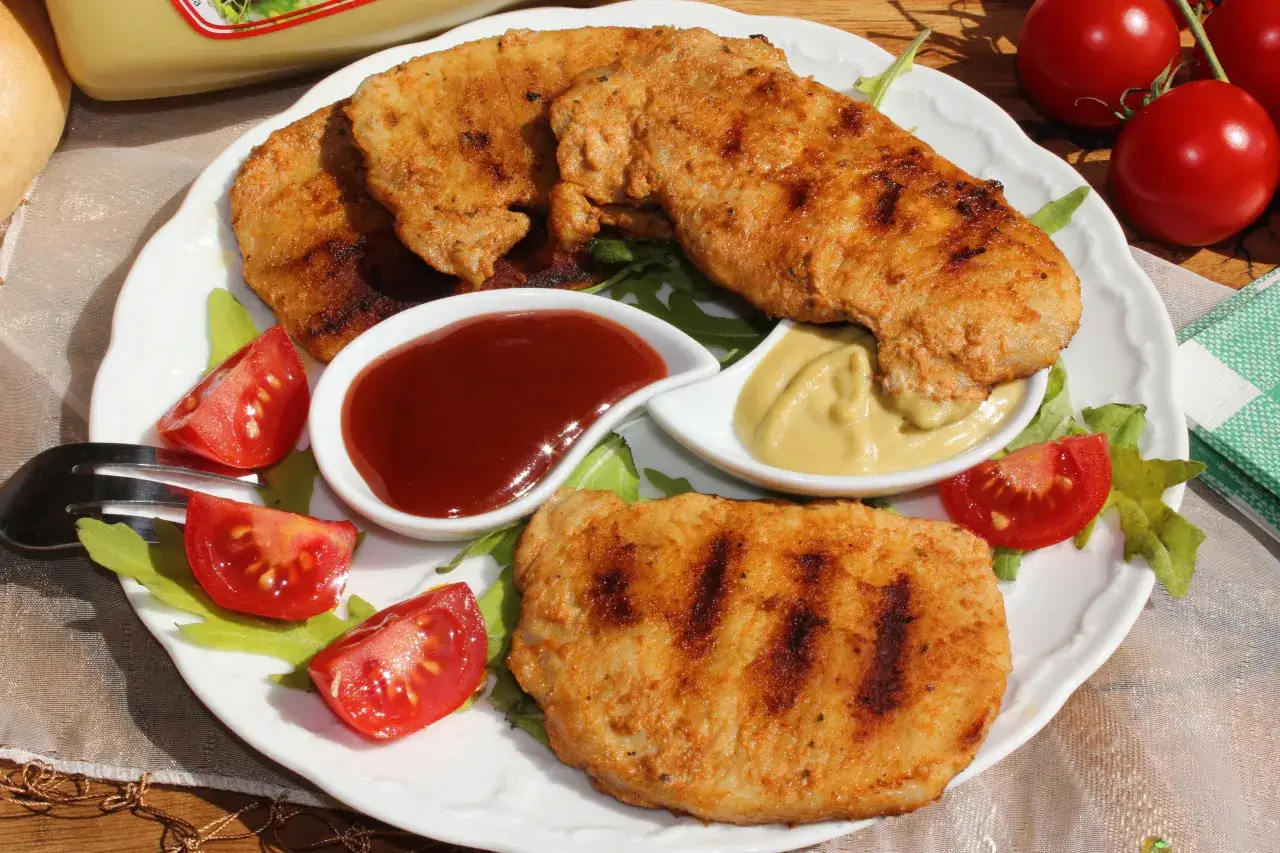 Idealna marynata do schabu na grilla bez nadmiaru soli: grillowany schab z sosem BBQ, musztardą i pomidorkami.