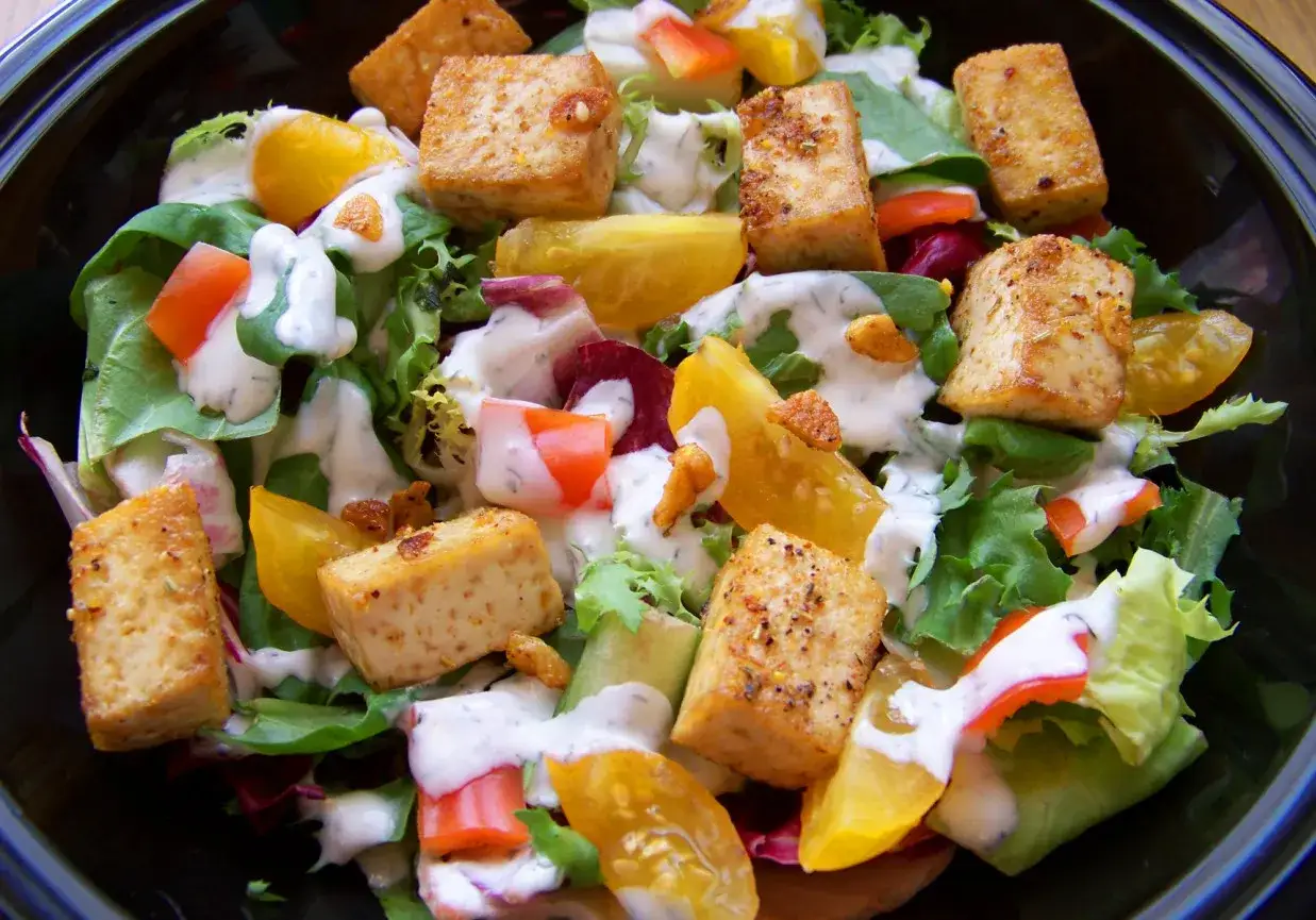 Sałatka z chrupiącym tofu, które smakuje jak ser feta, z kolorowymi pomidorami i kremowym dressingiem.