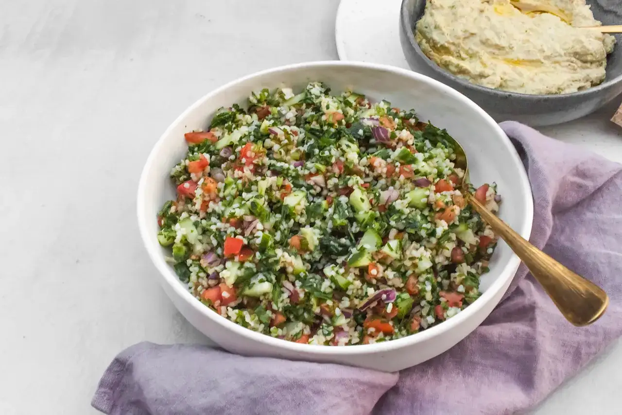 Kolorowa sałatka tabbouleh z komosą ryżową, pomidorami, ogórkiem i ziołami. Idealna alternatywa dla tradycyjnej wersji.