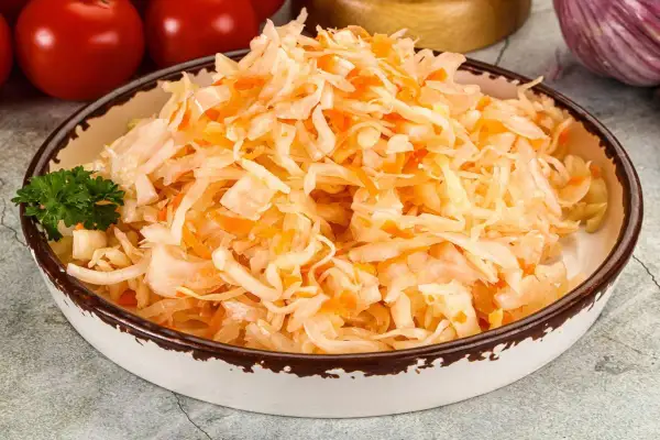 Miseczka z surówką z kiszonej kapusty i marchewki, idealna do przygotowania z miodem.