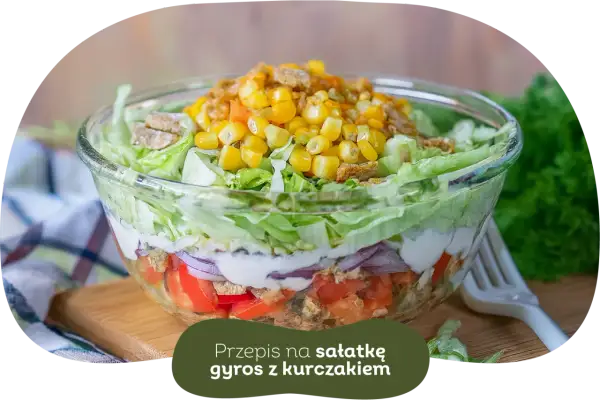 Warstwowa sałatka gyros z kurczakiem, pomidorami, cebulą i kukurydzą. Idealna, gdy zastanawiasz się, czy sałatkę gyros można zrobić dzień wcześniej.